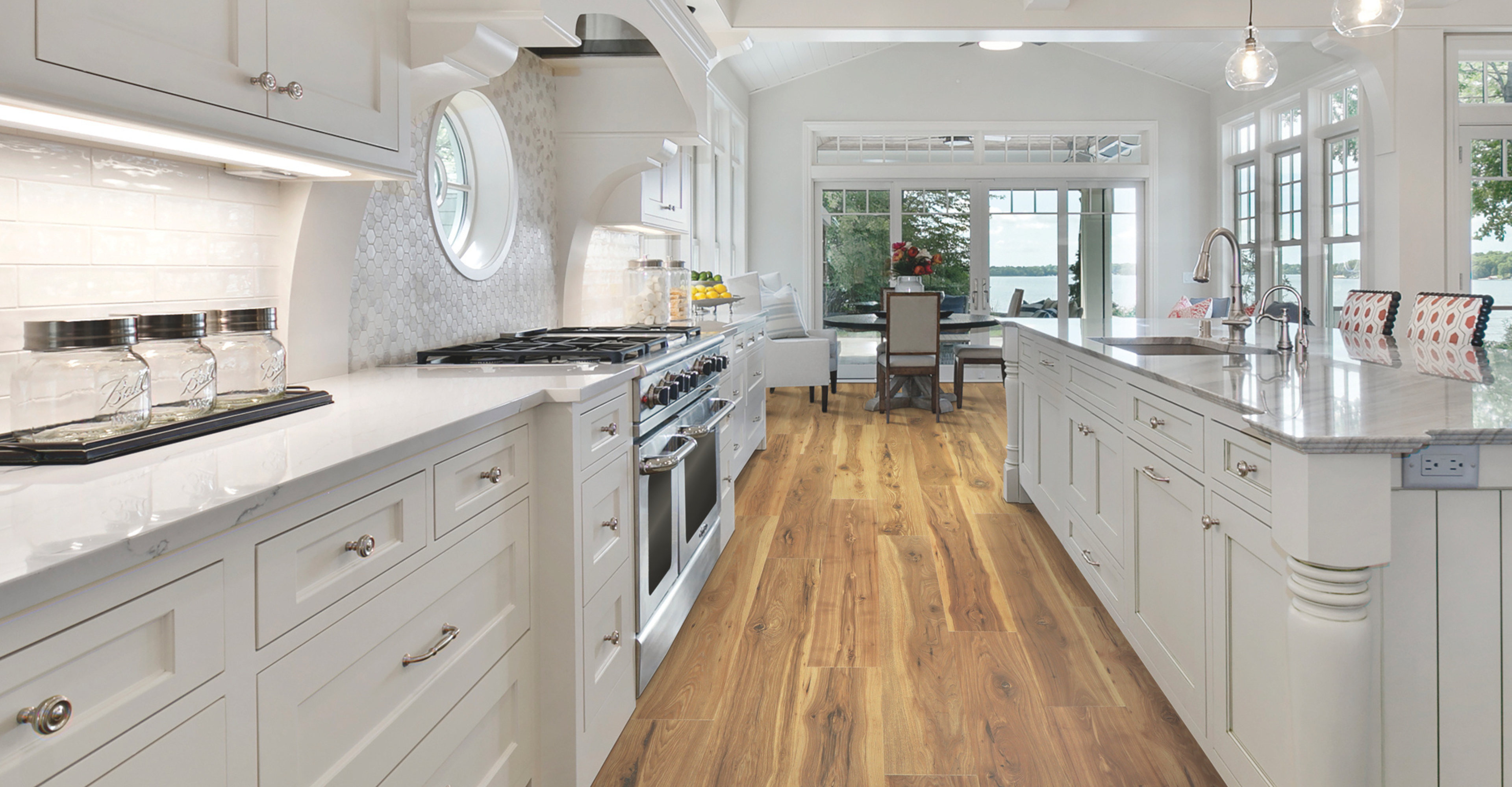 Kitchen with wood look flooring and white cabinetry and countertops